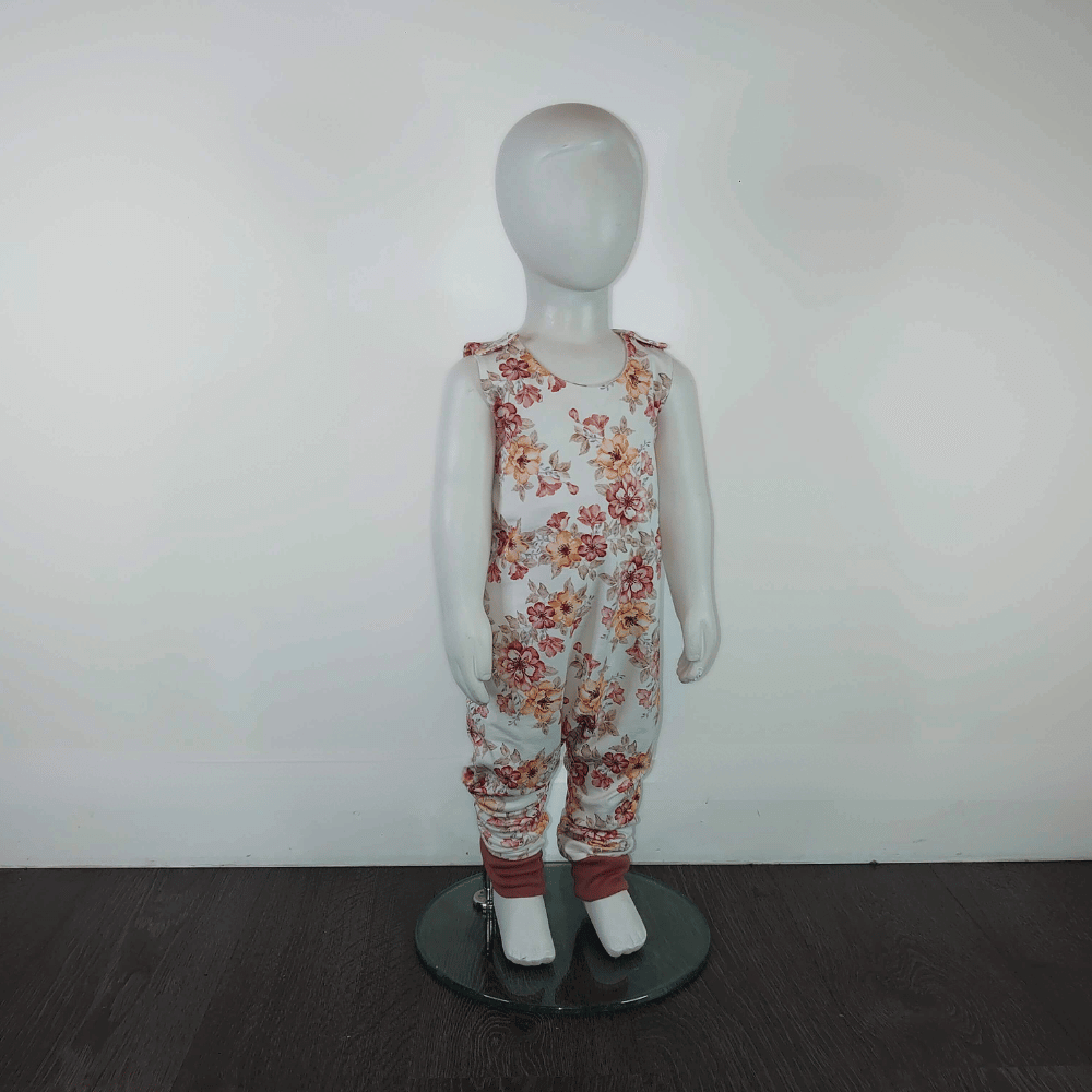 Baby romper with clay pink and light orange delicate flowers on mannequin.