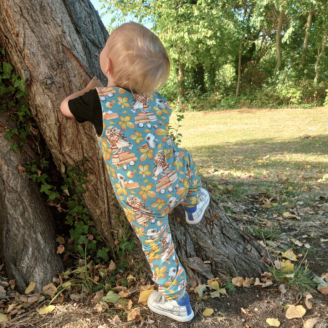 Boy wearing petrol blue romper with charming owl print, ideal for stylish and comfy everyday wear, back view
